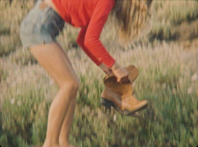 a woman bending over to pick up a pair of boots