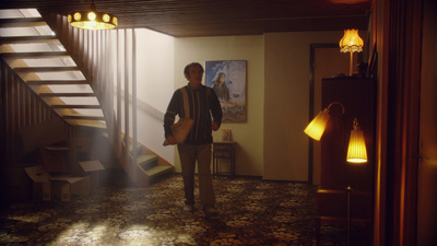 a man standing in a hallway with a guitar