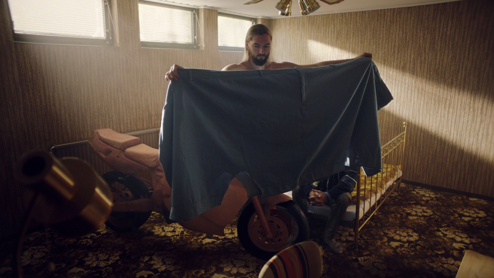 a man sitting on a scooter holding a blue sheet