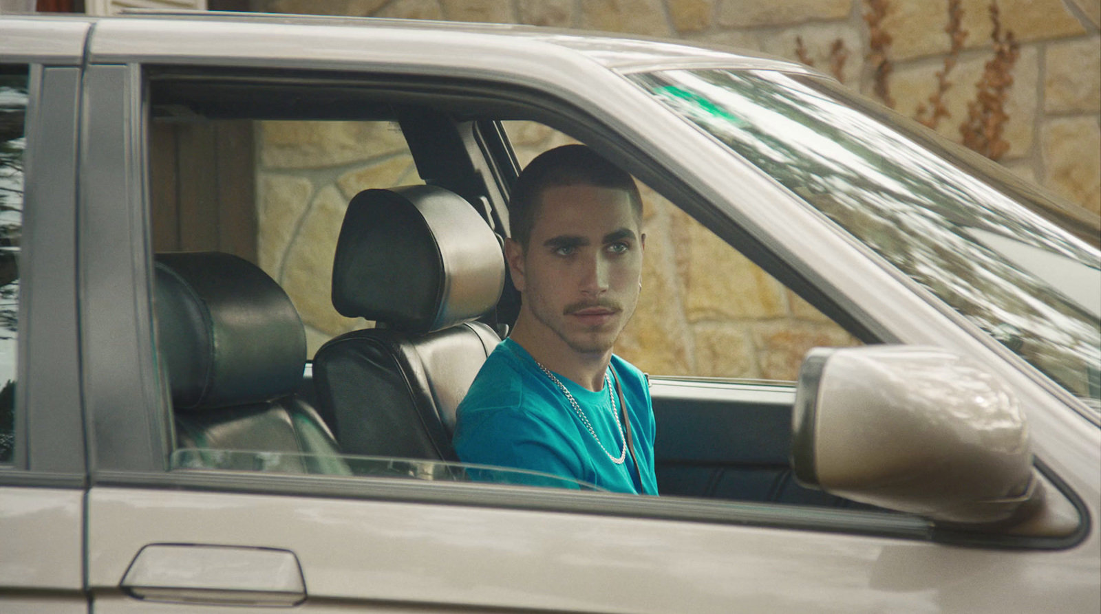 a man sitting in a car looking out the window