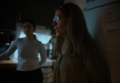 two women standing in a kitchen at night