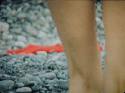 a close up of a person's feet walking on rocks