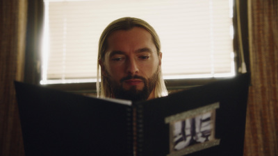 a man reading a book in front of a window