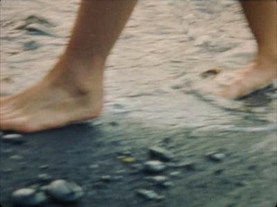 a close up of a person walking on a beach