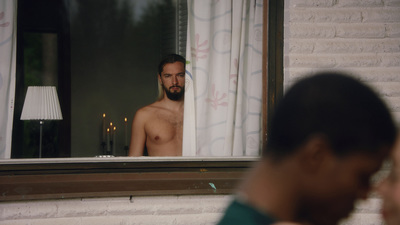 a man standing in front of a window next to a lamp