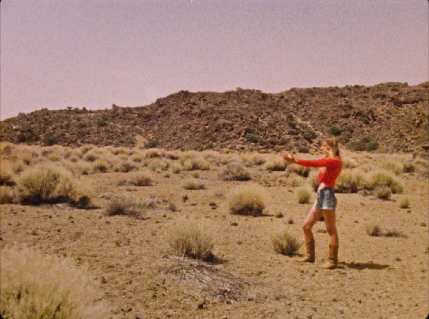 a woman standing in the middle of a desert