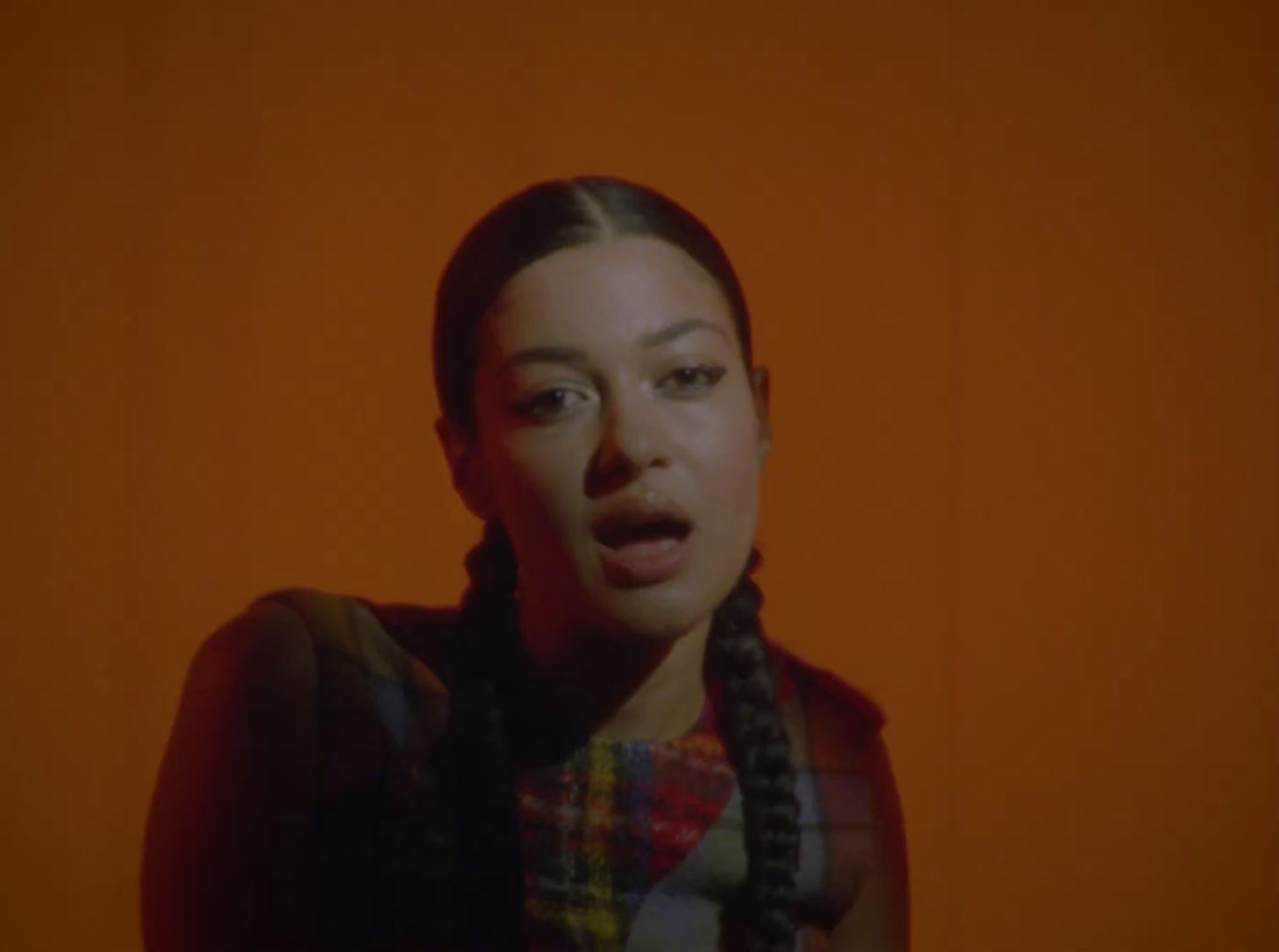 a woman with braids on her hair looking at the camera