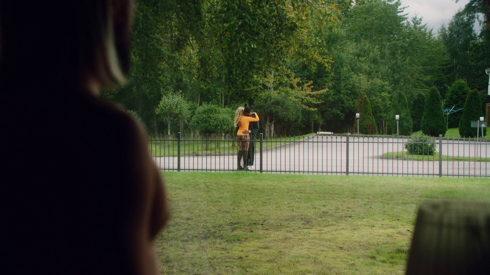 a woman taking a picture of a man in a yellow shirt