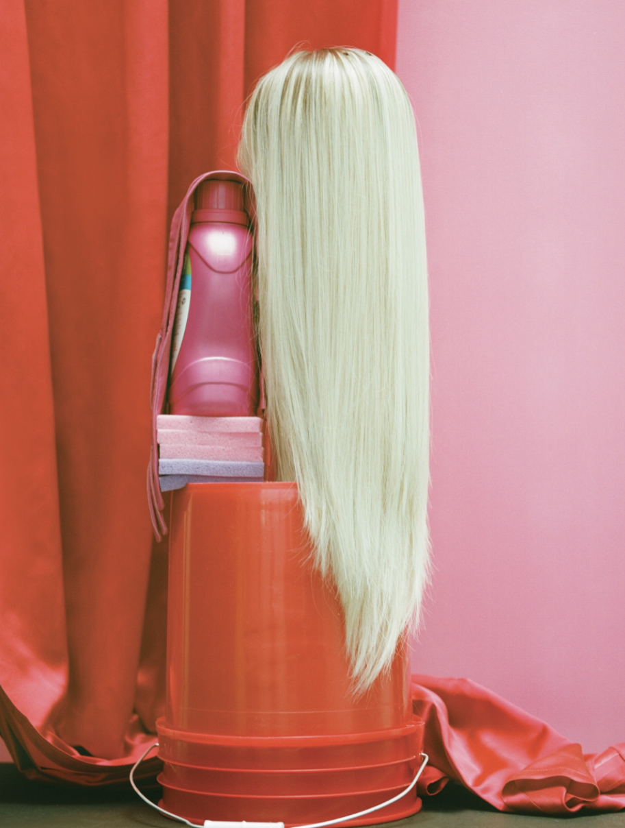 a hair dryer sitting on top of a table next to a red curtain