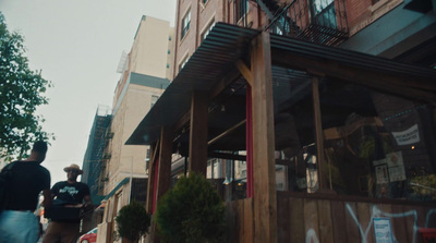 a man walking down a street next to a tall building