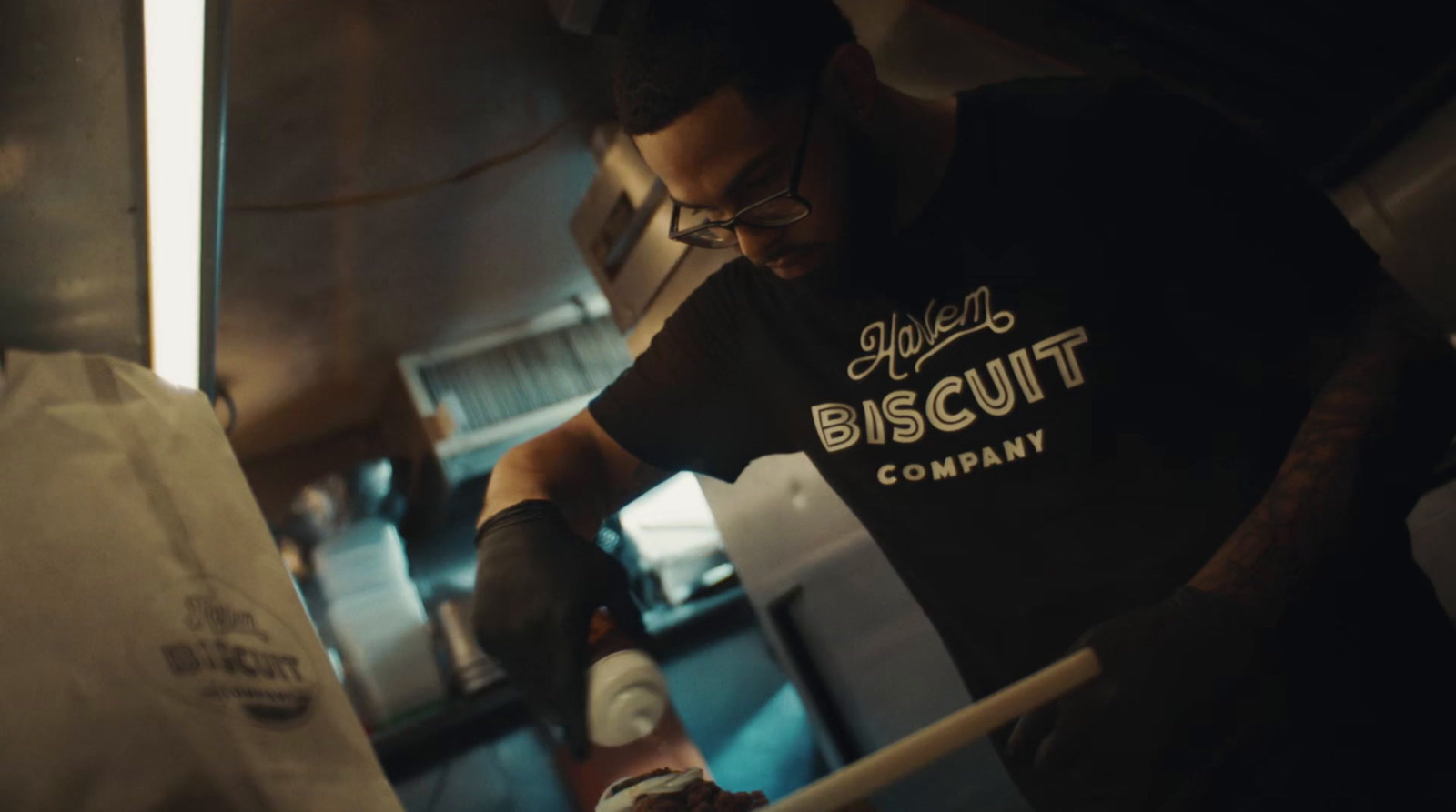 a man in a black shirt is preparing food in a kitchen