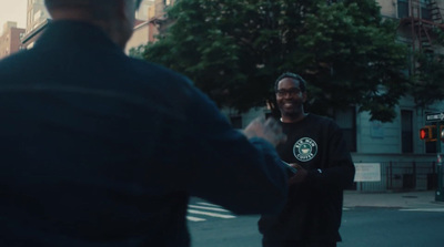 a man standing on the side of a road talking on a cell phone