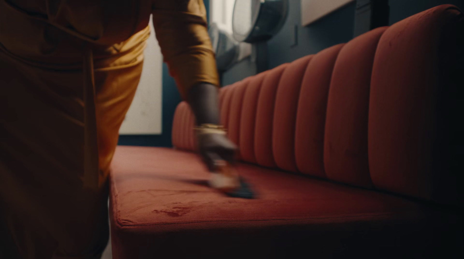 a person cleaning a red couch with a mop