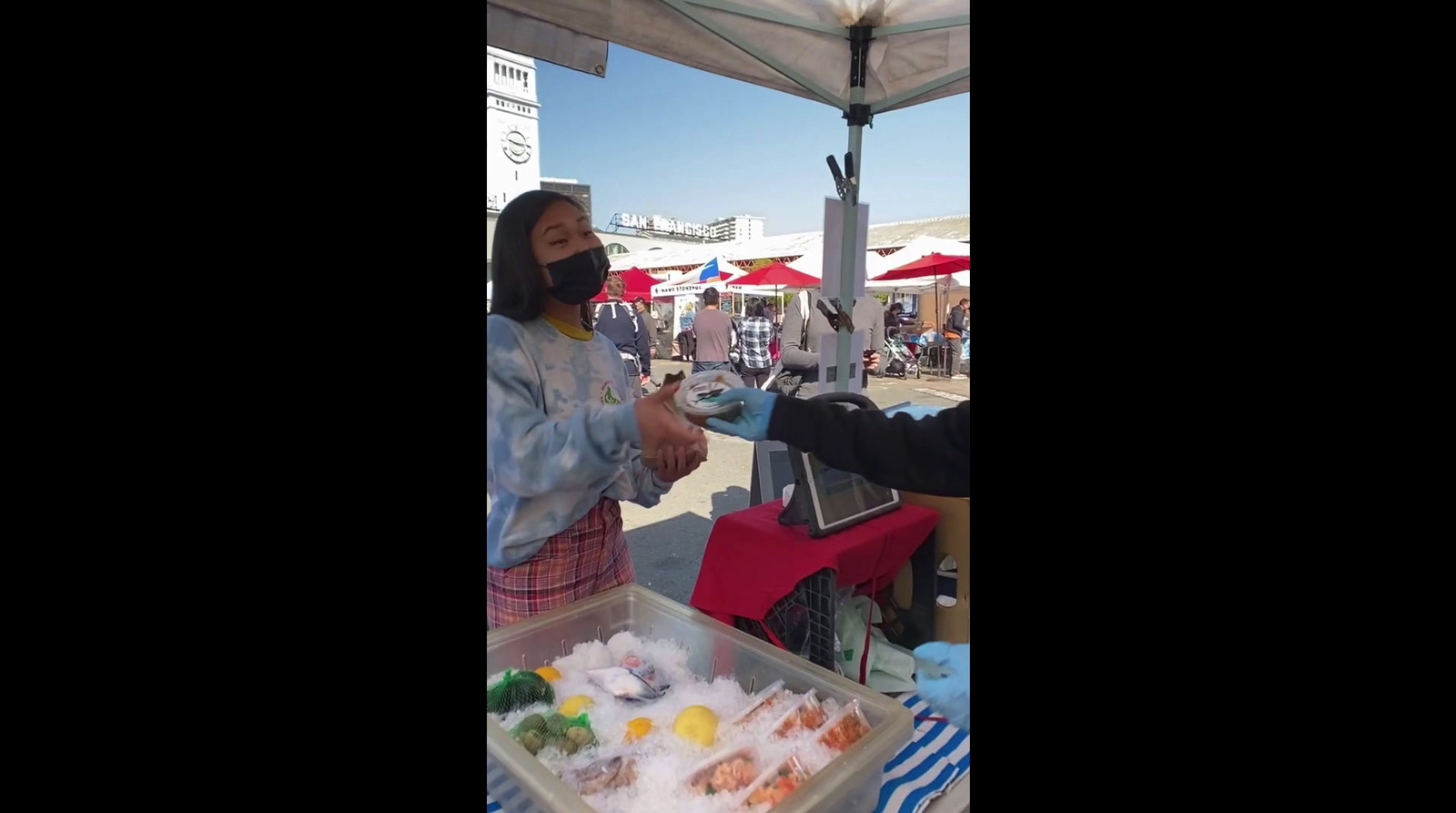 a woman wearing a face mask standing in front of a table