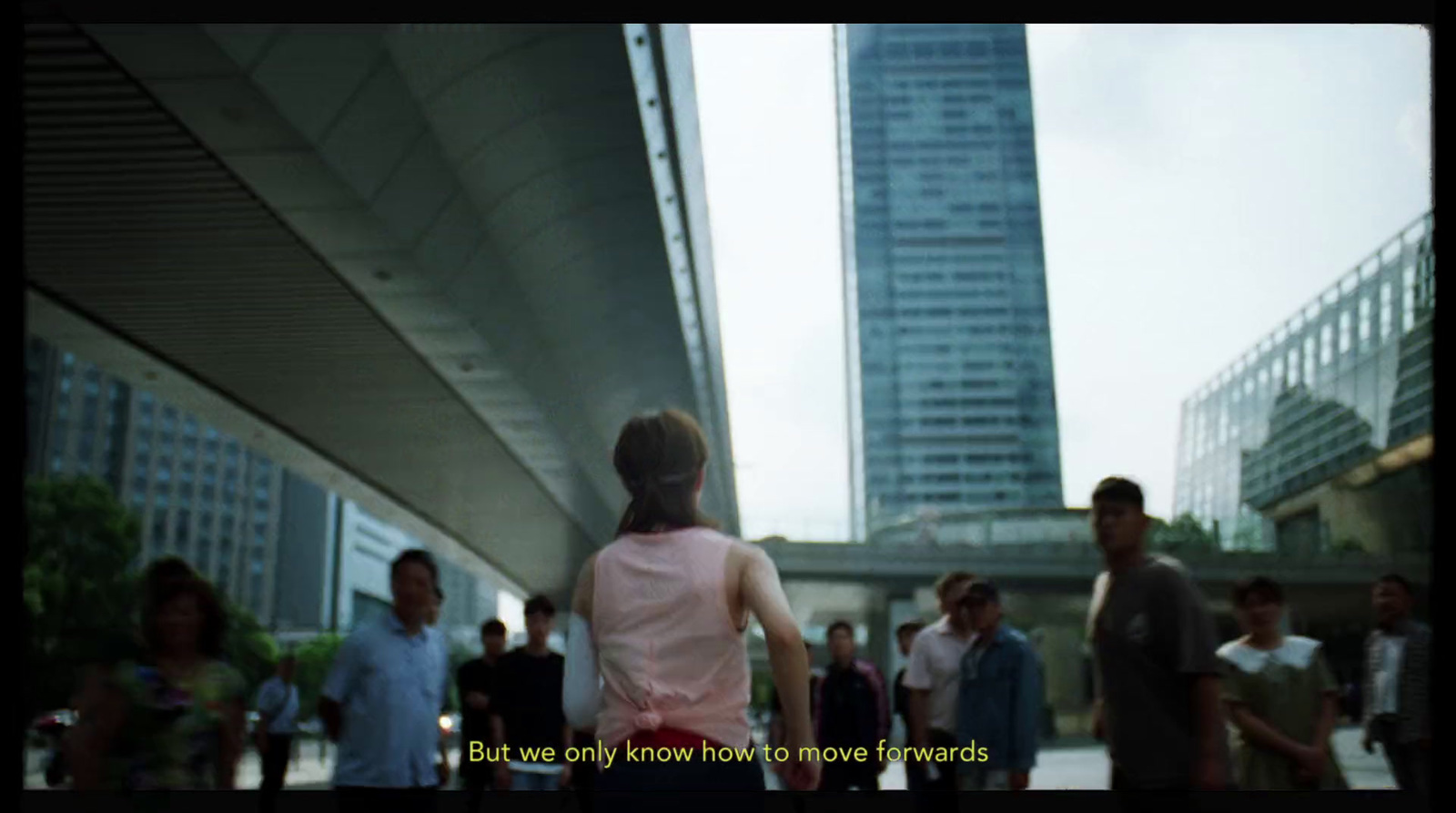 a group of people walking down a street next to tall buildings