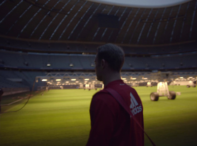 a man in a red shirt standing in front of a soccer field