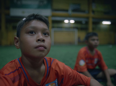 two young boys sitting on a soccer field