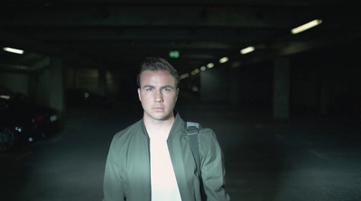 a man standing in a dark parking garage