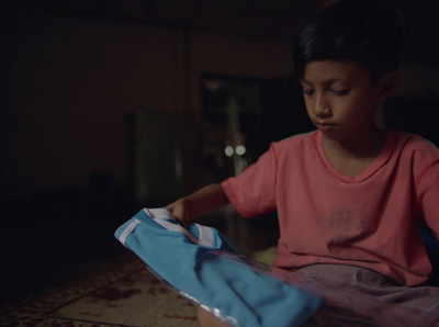 a young boy sitting on the floor opening a bag