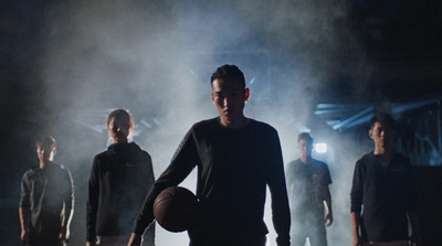 a man holding a basketball while standing next to other men