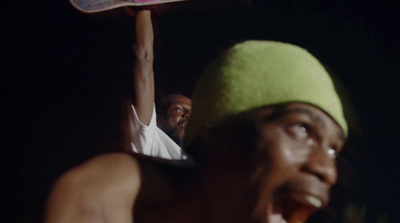 a man holding a skateboard on his shoulders