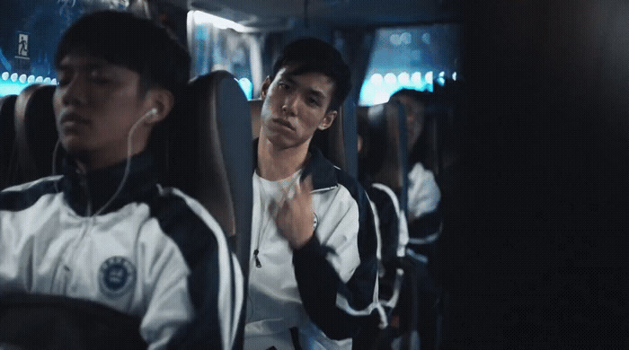 two men sitting on a bus with headphones in their ears