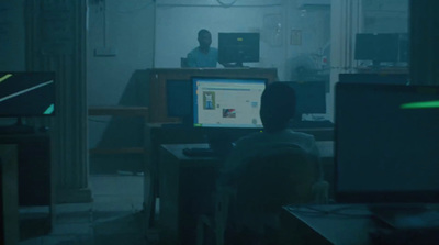 a man sitting in front of a computer monitor