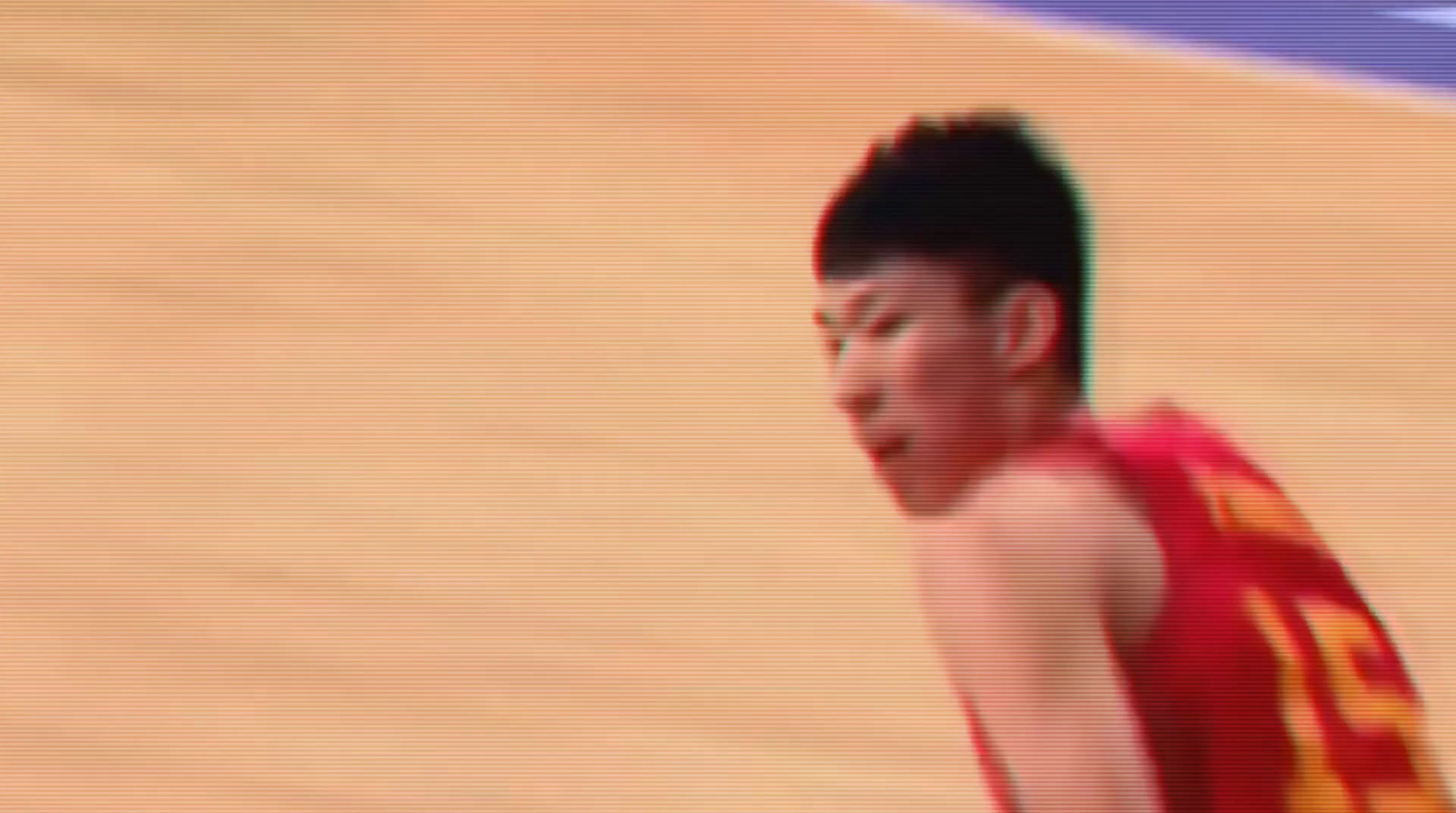 a man in a red and yellow uniform holding a basketball