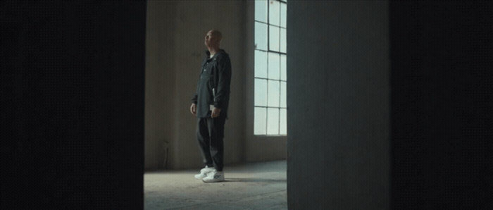 a man standing in front of a window in a dark room