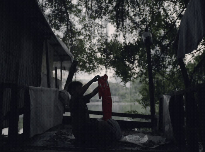 a woman sitting on a porch next to a tree