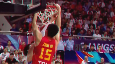 a basketball player dunking a basketball in front of a crowd