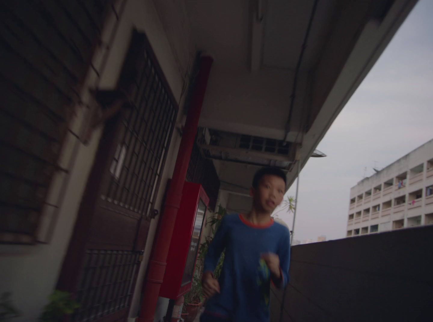 a man walking down a sidewalk next to a tall building