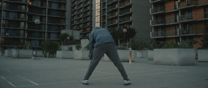 a person in a parking lot with a building in the background