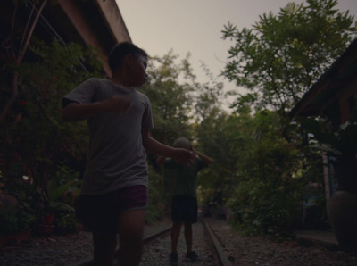 a man holding a frisbee while standing on a train track