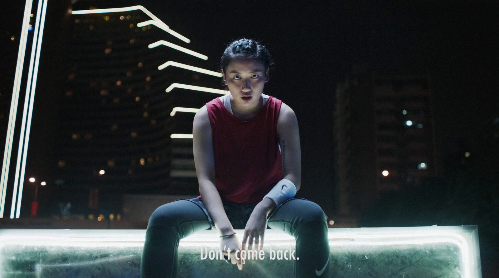 a woman sitting on top of a bench in the dark