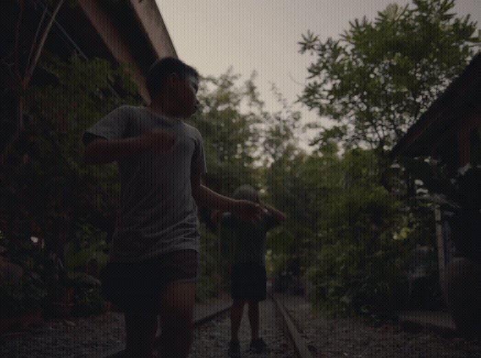 a man holding a baseball bat while standing on a train track