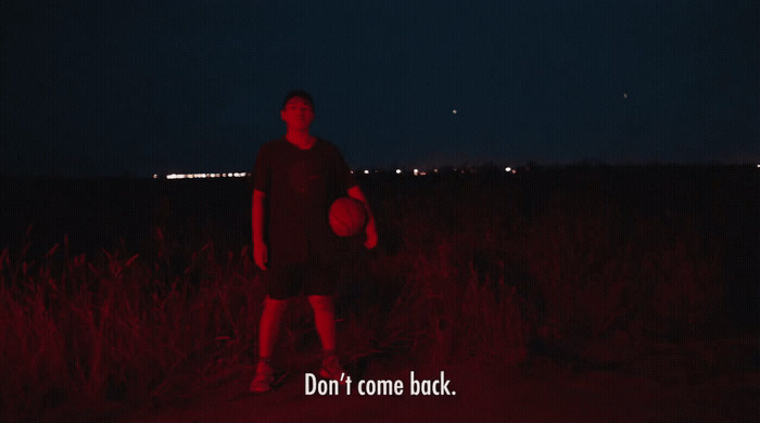 a man standing in a field holding a frisbee