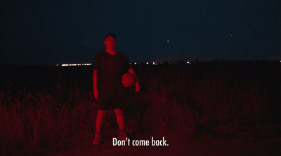 a man standing in a field holding a frisbee