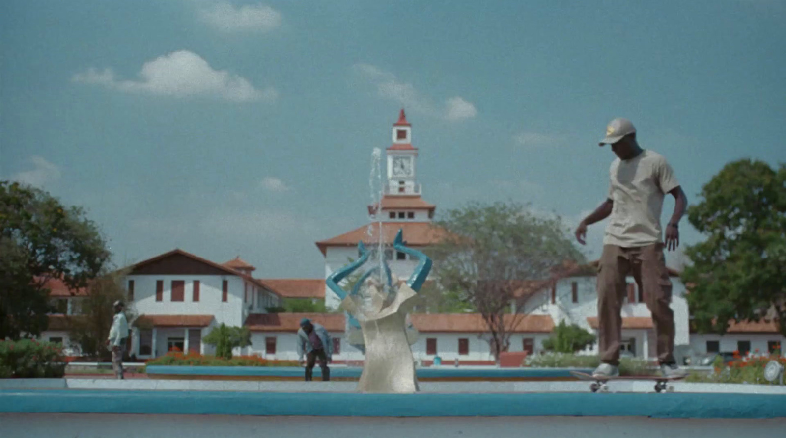 a man riding a skateboard next to a statue