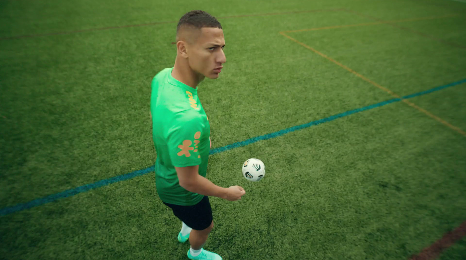 a man in a green shirt holding a soccer ball