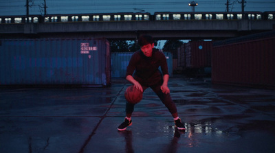 a man holding a basketball on top of a wet ground