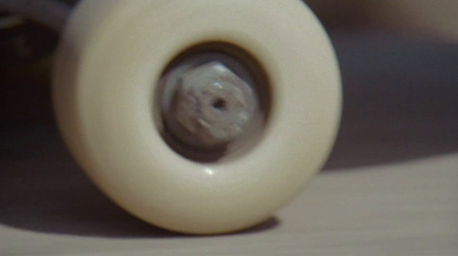 a close up of a skateboard with a white wheel