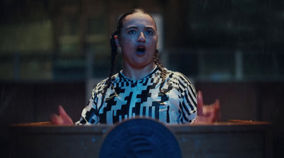 a woman standing in front of a podium talking on a cell phone