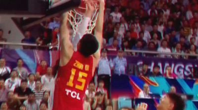 a man dunking a basketball in front of a crowd