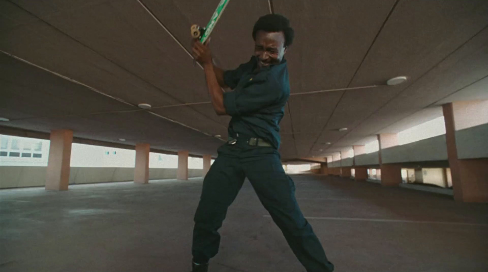 a man holding a tennis racquet in a parking garage