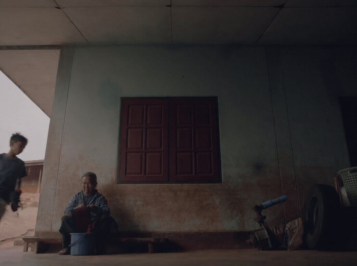 two men sitting on a bench in front of a building