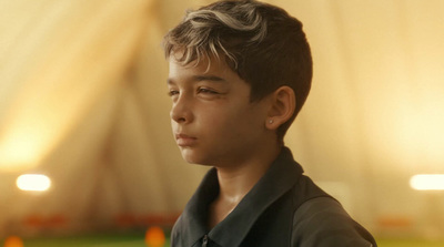 a young boy in a black shirt is staring at something