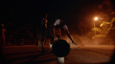 a man riding a skateboard down a street at night