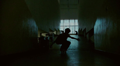 a man riding a skateboard down a dark hallway