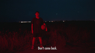 a man standing in a field at night holding a frisbee